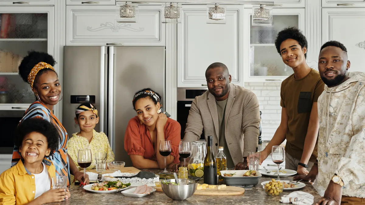 A happy Black family surrounds a kitchen island