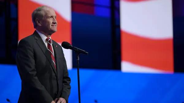Stuart Bell stands at a microphone.