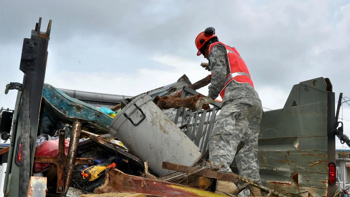 Puerto Rico National Guard Soldiers, along with volunteers of the Puerto Rico State Guard, work together to fulfill the road clearing mission at Punta Santiago in Humacao, PR, Sept. 27, 2017.