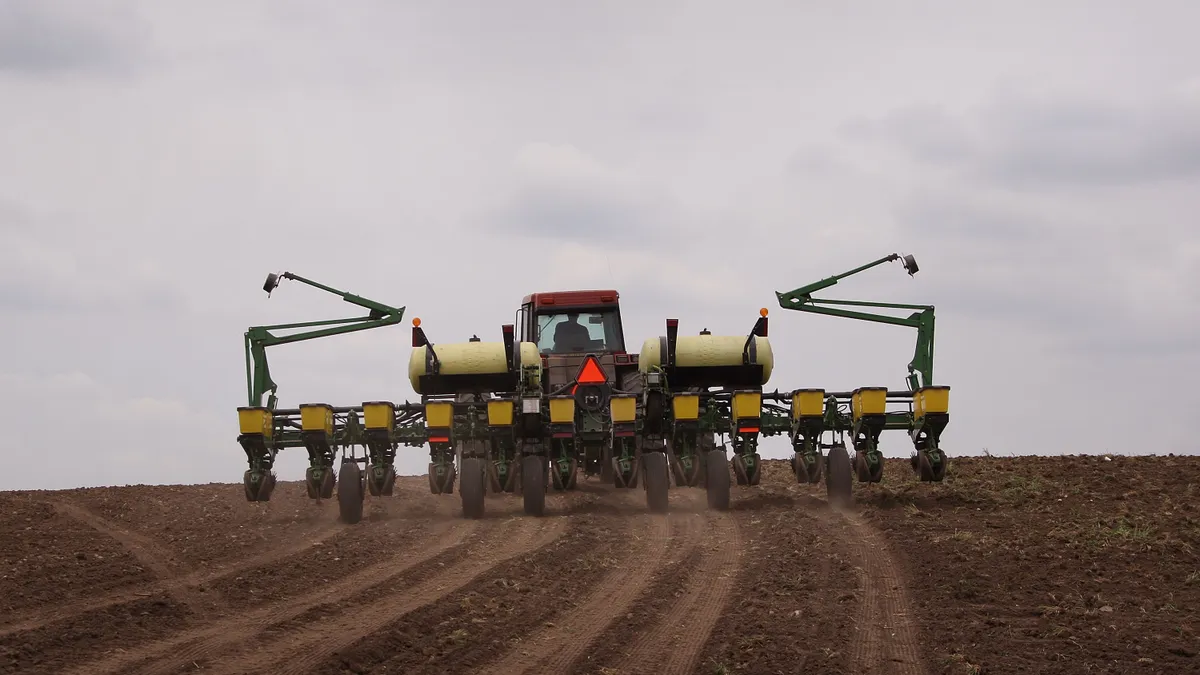 A farm machine is seen on a brown field