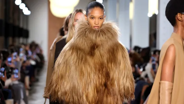 A model is a voluminous fur coat walks down a runway.