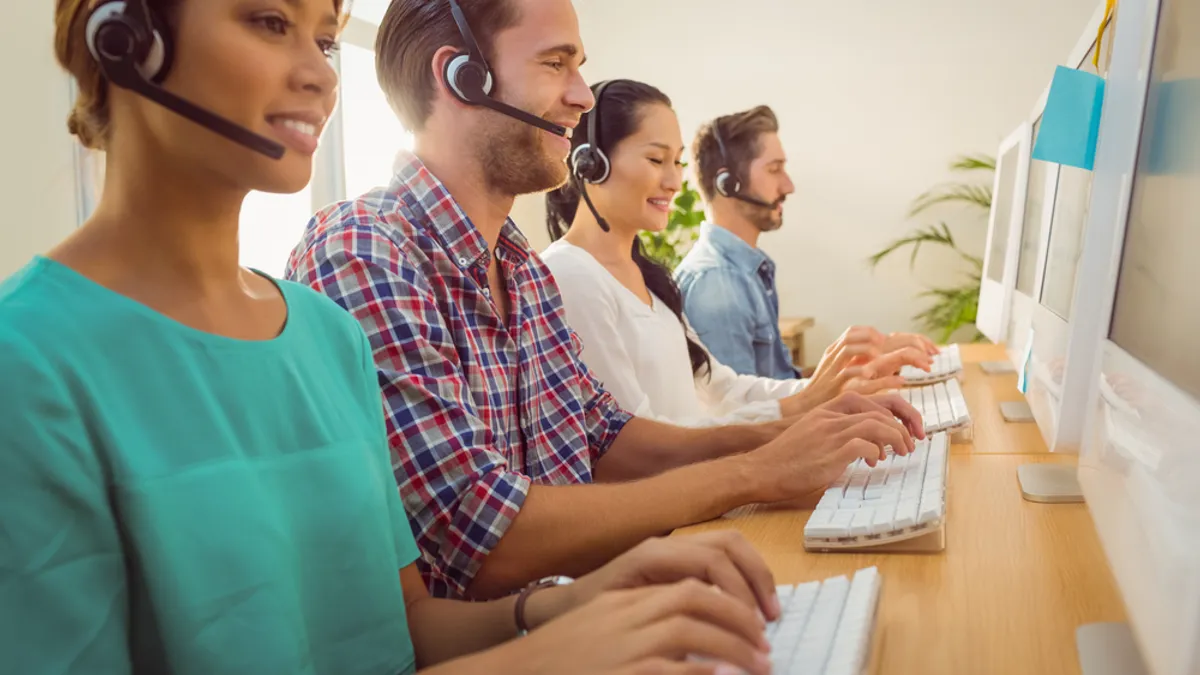 Team of people wearing headsets working on computers