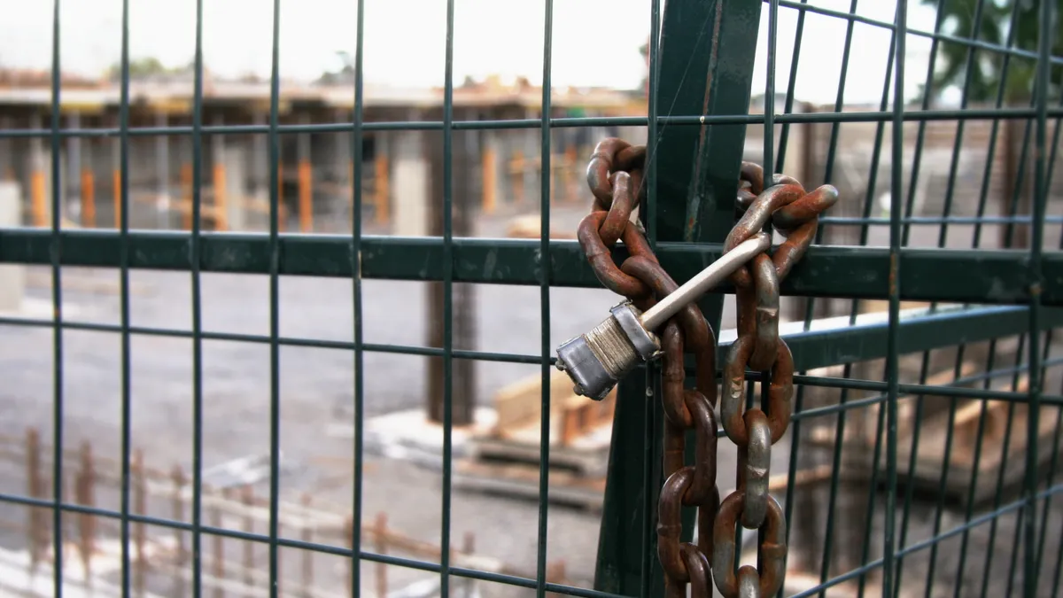 A chain lock over a gate on a construction site.