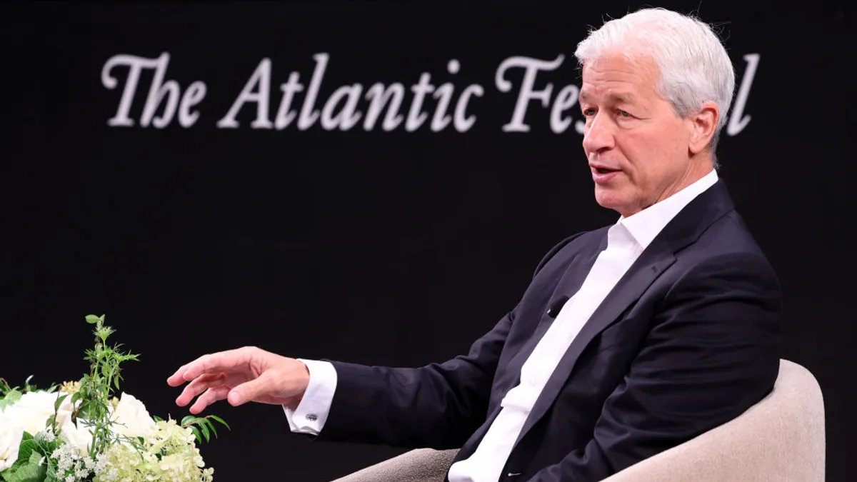 JPMorgan CEO Jamie Dimon, seated near a floral arrangement, speaks during an event hosted by The Atlantic.