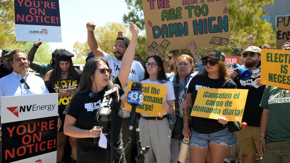 protesters hold signs including "the rates are too damn high"