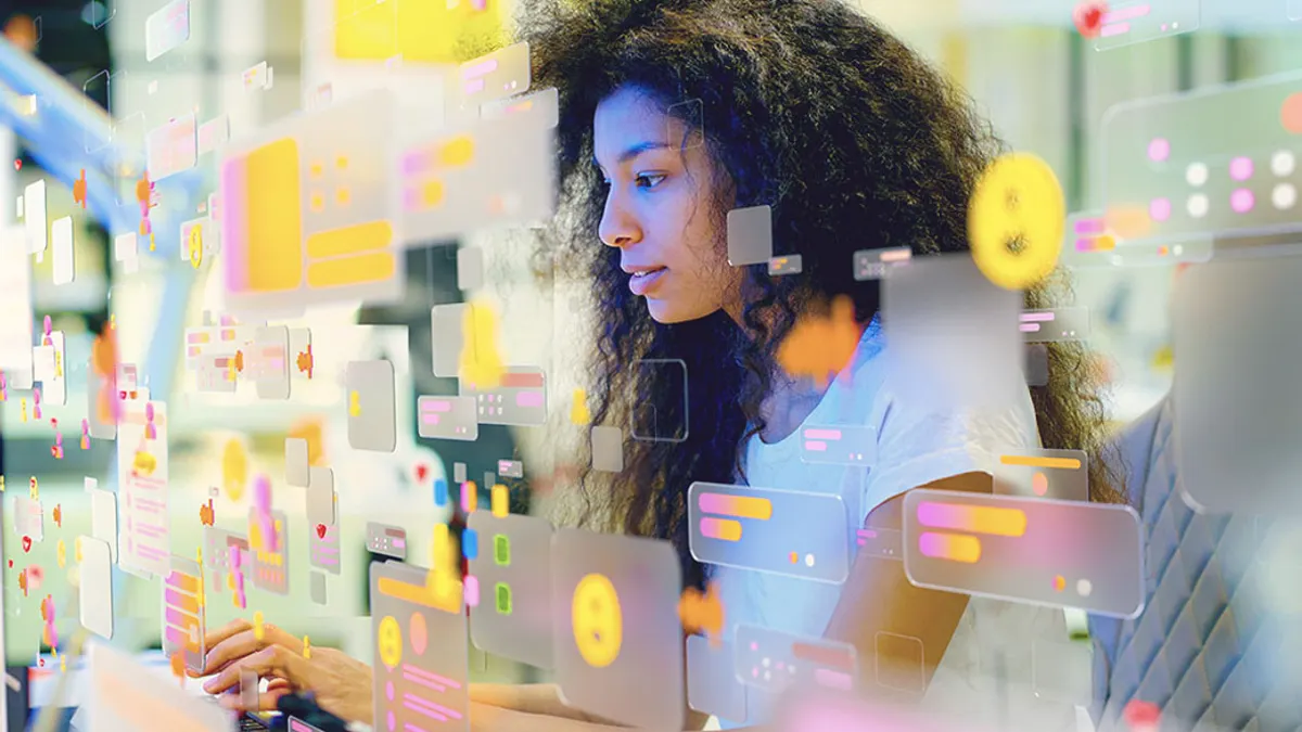 Portrait of a person working in modern office surrounded by multicolored social media icons and data screens.