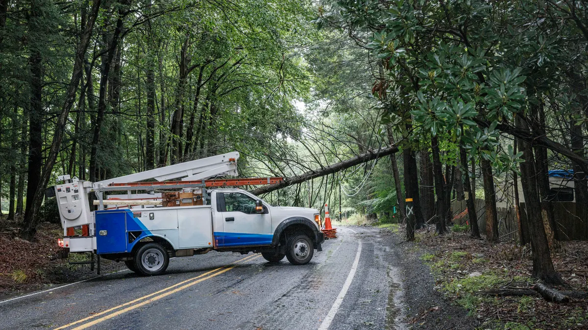 A utility truck near a downed power line.