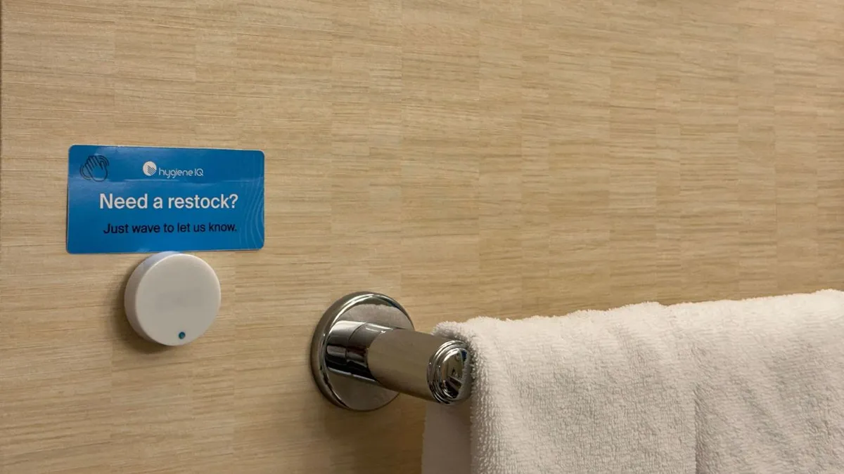 A sensor is next to a towel rack.