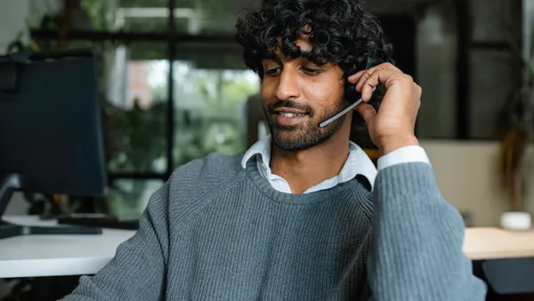 Person taking a call at a call center desk.