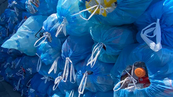 stacks of blue bags filled with recycled beverage containers