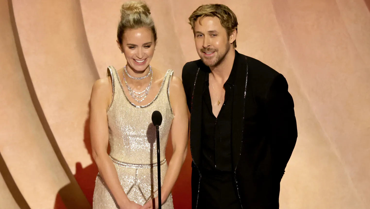 Emily Blunt in a sequined gown and Ryan Gosling in a black suit with sequined trim.