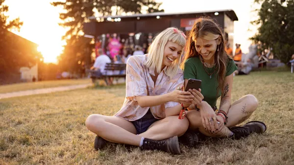 Two people look at a smartphone at an outdoor event