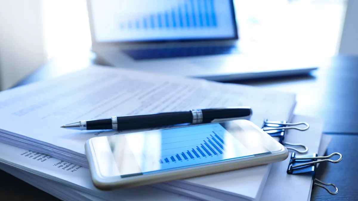 A ballpoint pen and a mobile phone, displaying a bar graph.