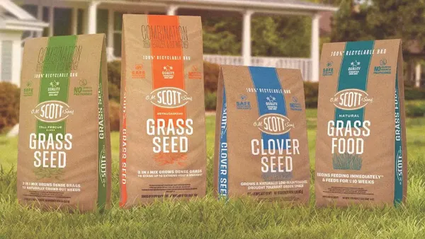 Four bags of ScottsMiracle-Gro lawn care products in paper bags.