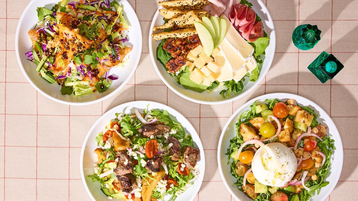A photograph of four salads on a checkered table.