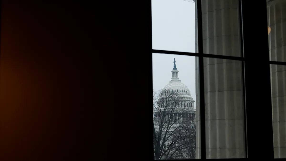 The U.S. Congress building is shown through a window.