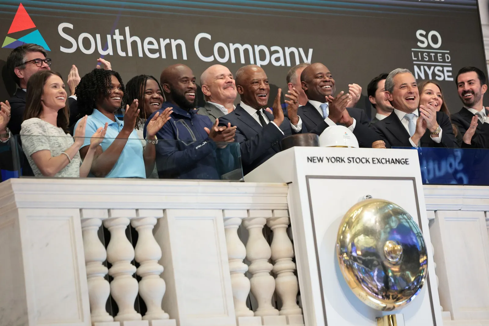 A group of people standing in front of a sign that says "Southern Company"