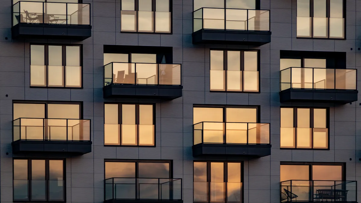 The evening sun is reflected in the modern apartment building with balconies.