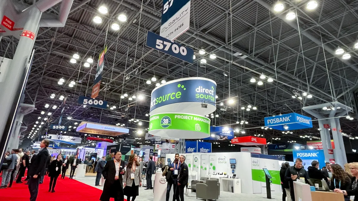 An exhibition floor at a conference filled with vendor booths and people.