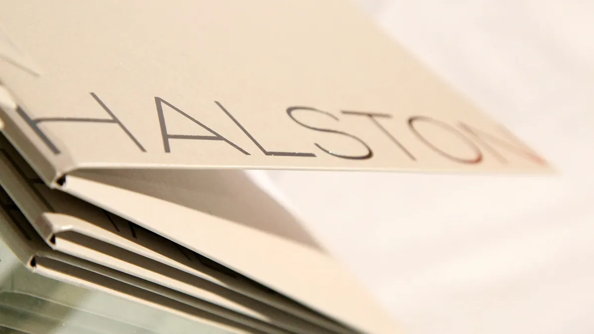 A close up of books with the Halston logo on the cover.