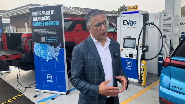 EVgo CEO Badar Kahn stands in front of GM Energy co-branded chargers