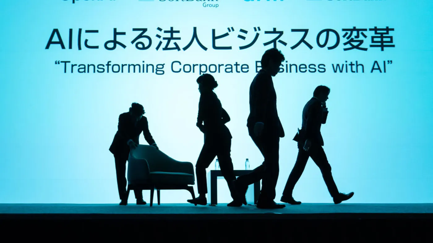 Silhouettes move a stage set against a pale teal background. The sign reads "Transforming Corporate Business with AI" in both English and Japanese.