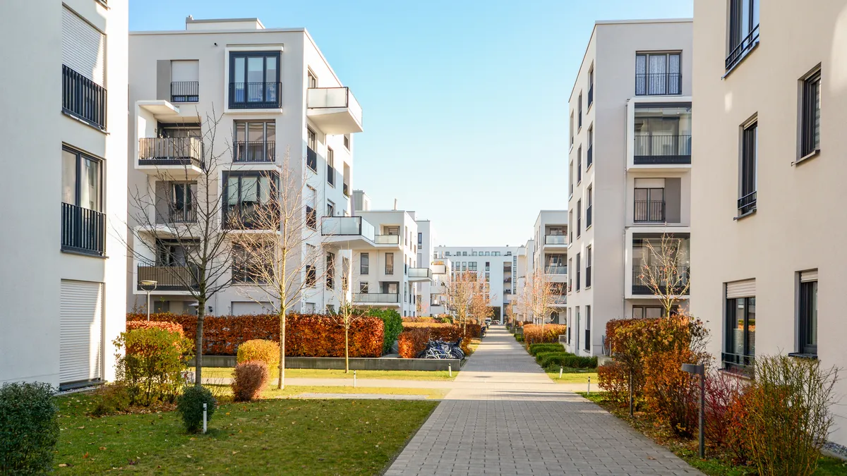 White apartment buildings surrounded by trees without leaves