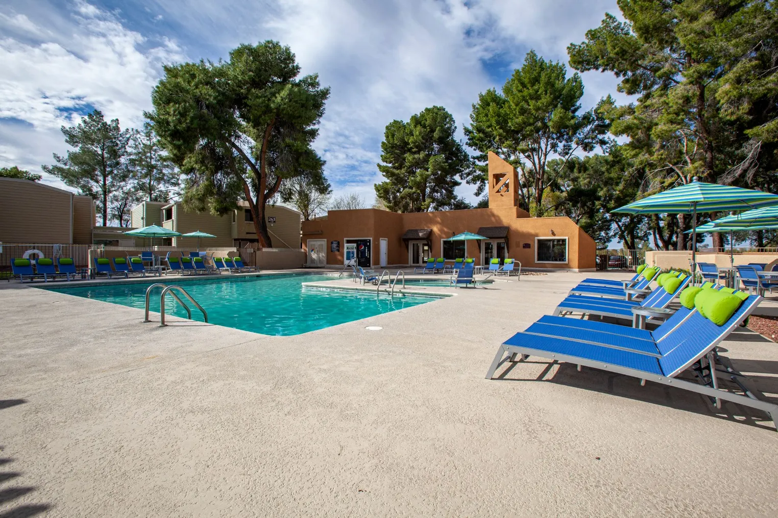 pool and chairs with apartments in the distant