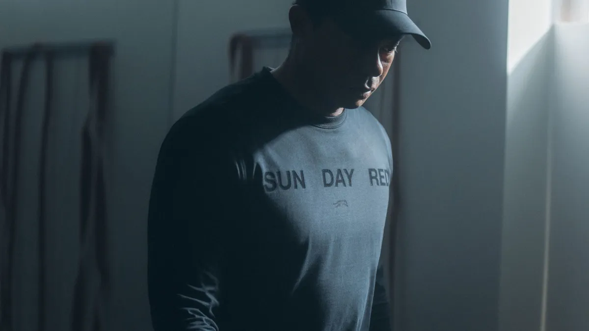 Tiger Woods in a dark blue long sleeves t-shirt with the words Sun Day Red on the front.