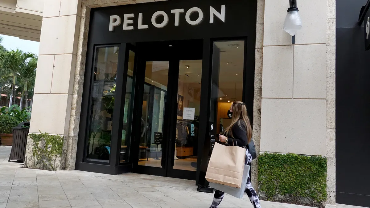 A person walks past a Peloton store.