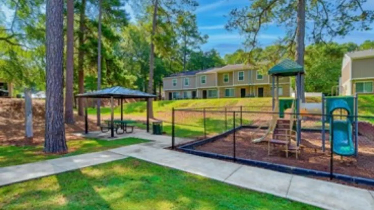 Playground with brown apartment community in the background.