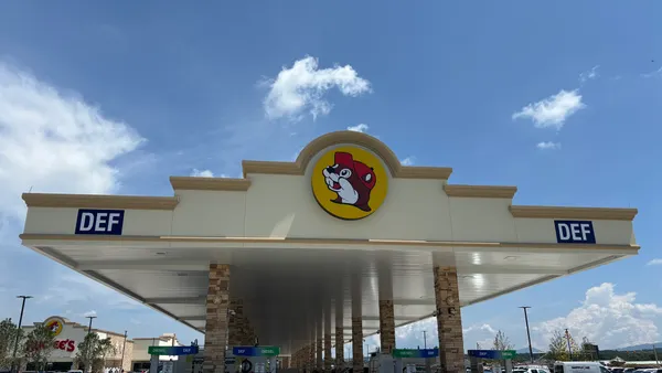 A photo of the fuel canopy at a gas station. A logo on the canopy shows a beaver wearing red clothing inside a yellow circle.