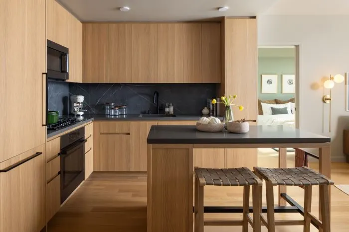 an apartment kitchen with light-wood cabinets