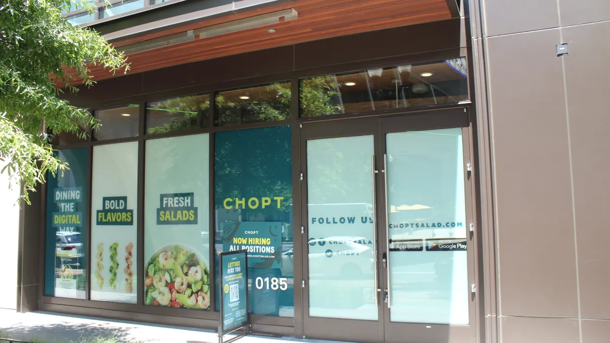 An exterior shot of a restaurant front with teal colored window tints.