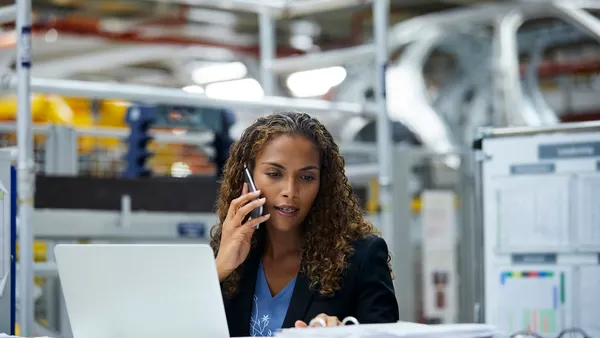 Young businesswoman using technologies at desk