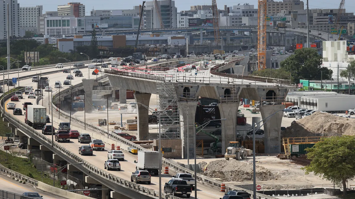 Construction workers build the “Signature Bridge,” replacing and improving a busy highway intersection at I-95 and I-395 on March 17, 2021 in Miami, Florida.