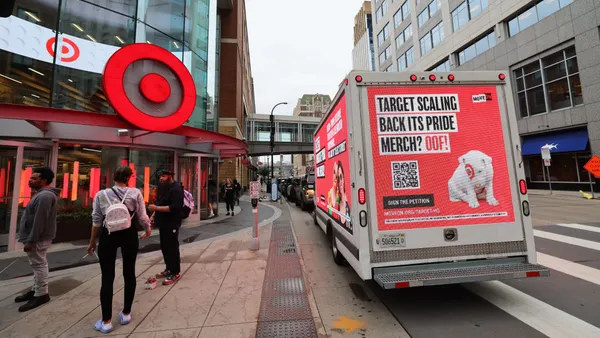A truck with a message is parked outside a store.