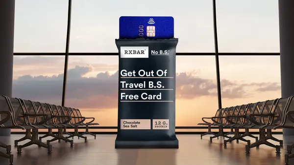 A giant black RXBar with a gift card peeking out of the top of the packaging stands in a glossy rendition of an airport gate.