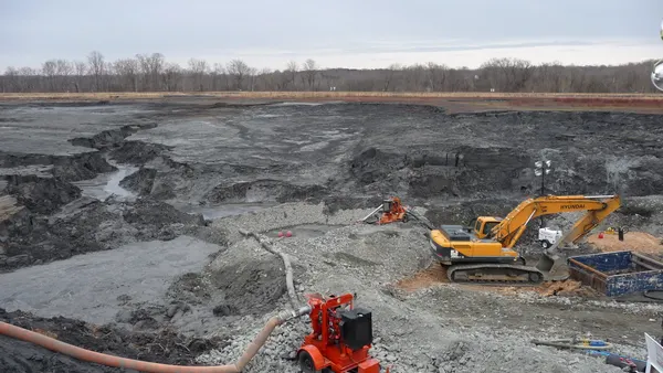 Heavy equipment moves material in a pit.