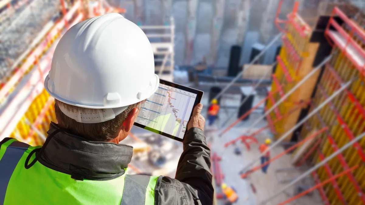 Construction worker on site looking at data on iPad