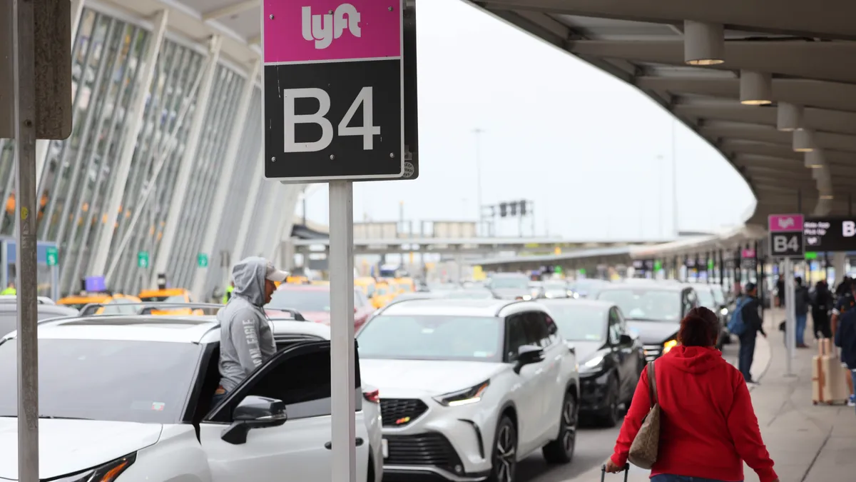 People wait for cars in the Lyft pick-up area at JFK Airport on April 28, 2023 in New York City.