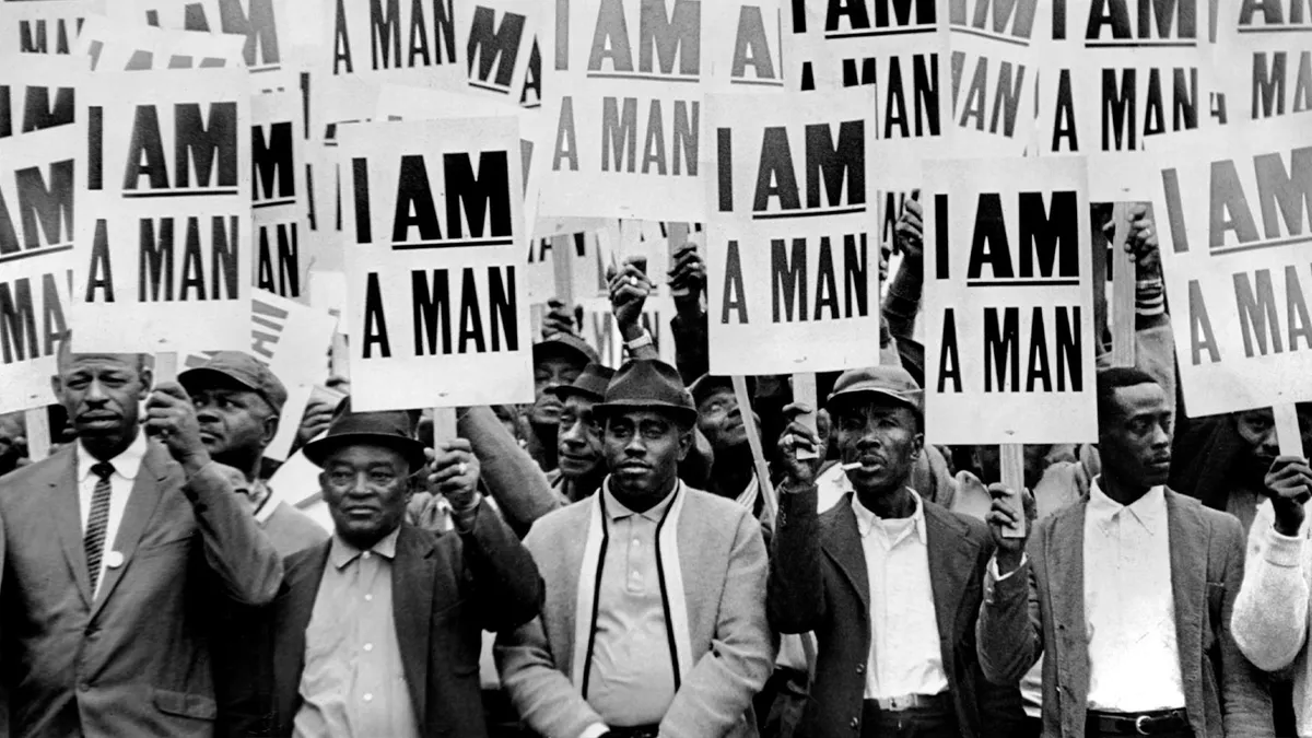 Striking workers in 1968 hold signs that say "I AM A MAN."