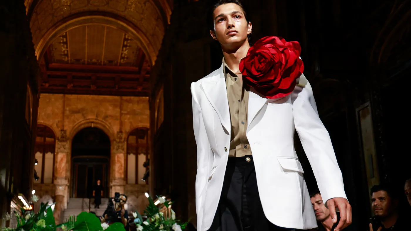 A model in a white suit jacket with a giant red flower on the lapel walks the runway during the Willy Chavarria fashion show during New York Fashion Week on September 13, 2023.