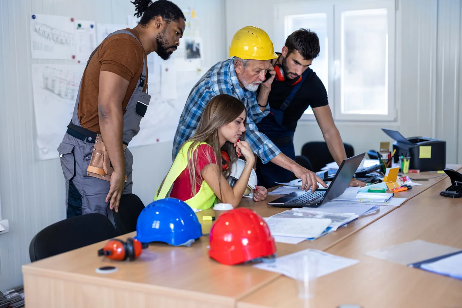 Multi-ethnic group of construction workers working in an office space.