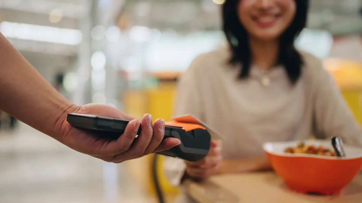 Customer service, street food and phone payment for food, food and breakfast with POS machine and waiter hands.