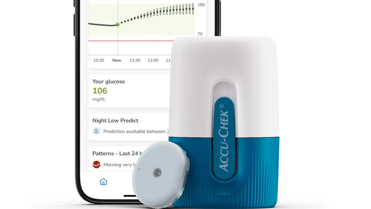 A rounded deivce that says "Accu-Chek" is in front of a phone showing a glucose prediction