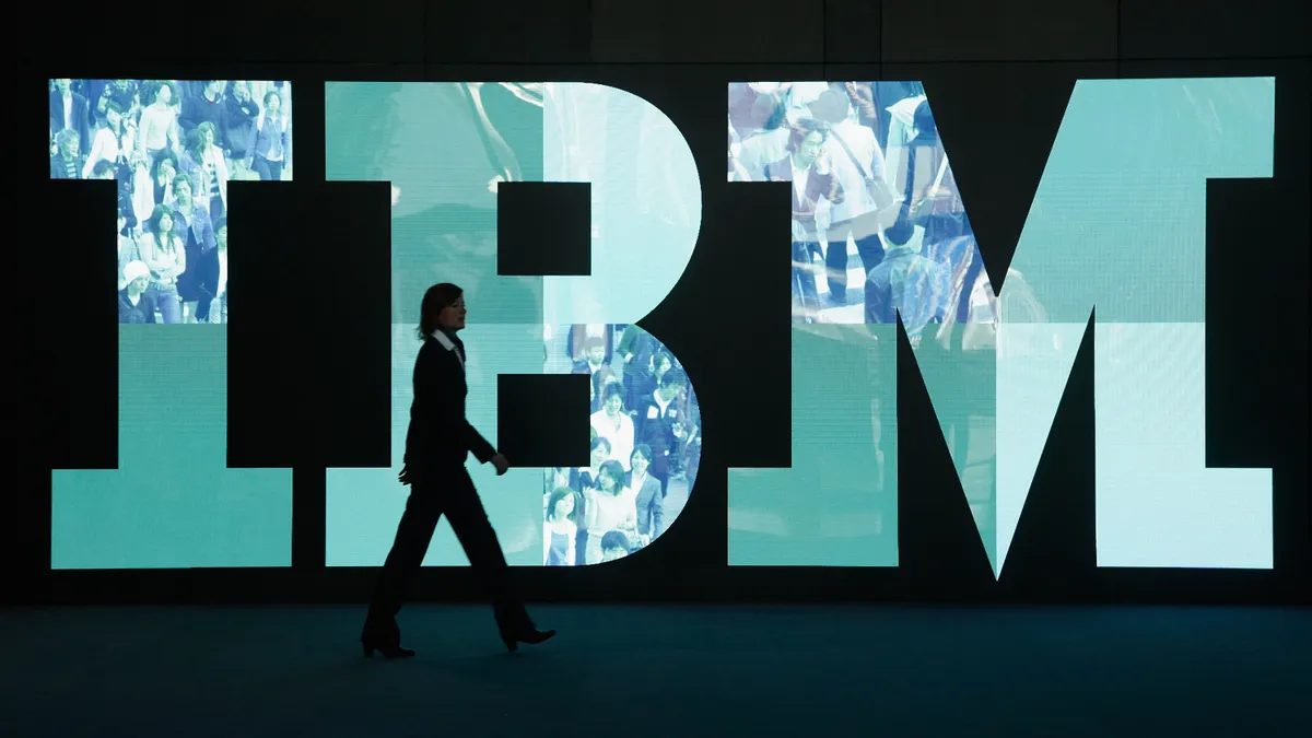 A woman walks past the IBM logo at the CeBIT technology trade fair the day before the fair's official opening on February 28, 2011 in Hanover, Germany.