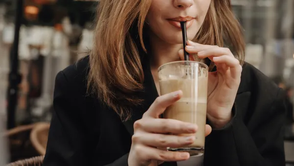 Woman drinking iced coffee outside