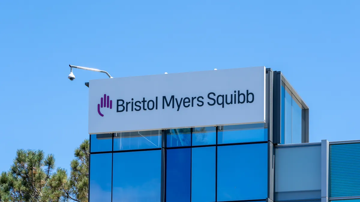 A sign spelling Bristol Myers Squibb hangs on the side of an office building.
