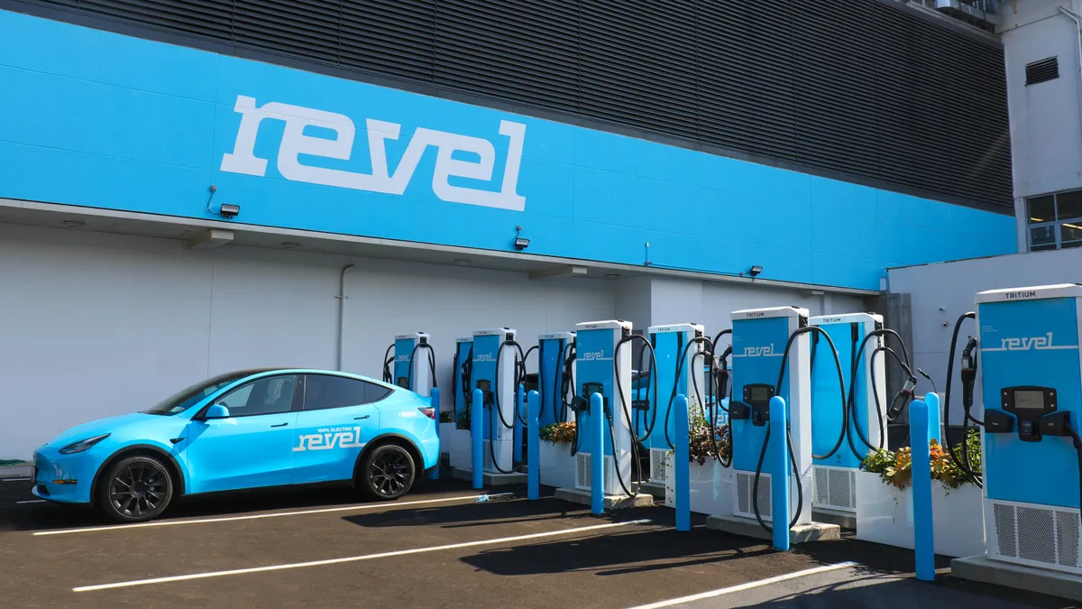 A row of Revel electric vehicle chargers pictured with one vehicle.